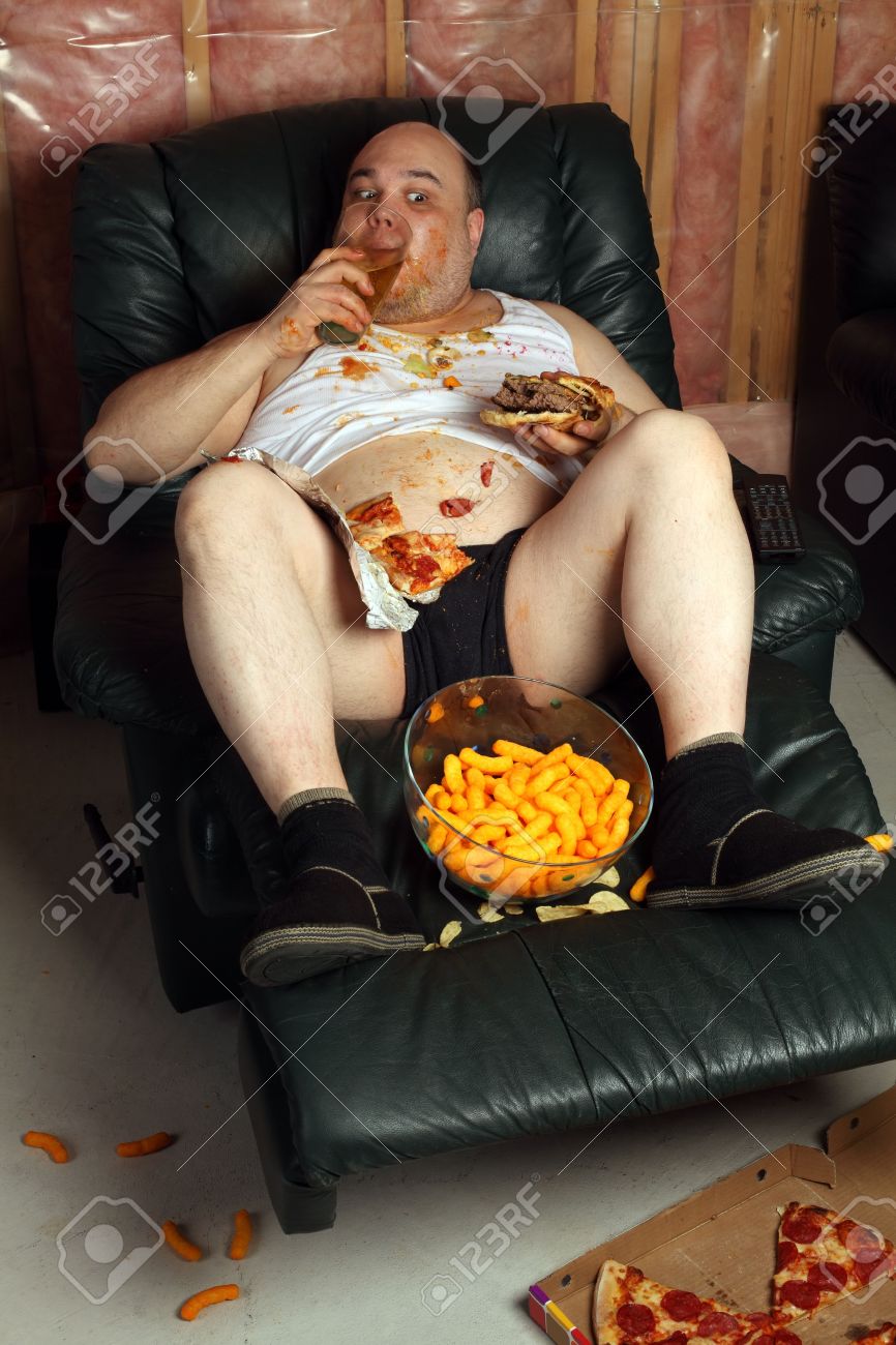 9899240-Lazy-overweight-male-sitting-on-a-couch-watching-television-Harsh-lighting-from-television-with-slow-Stock-Photo.jpg