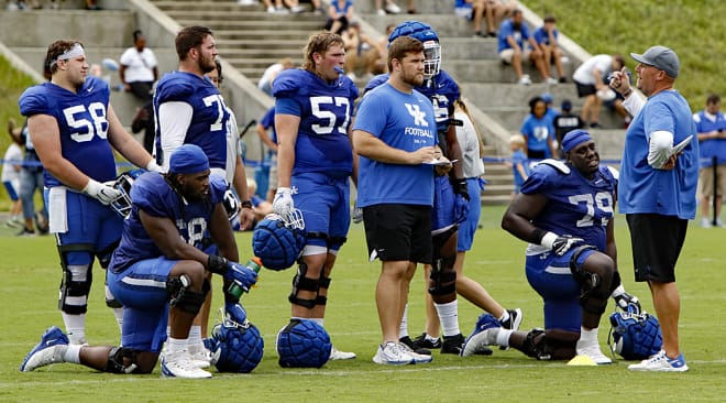 Kentucky offensive line coach Zach Yenser (far right) spoke with some of his unit during a recent practice.