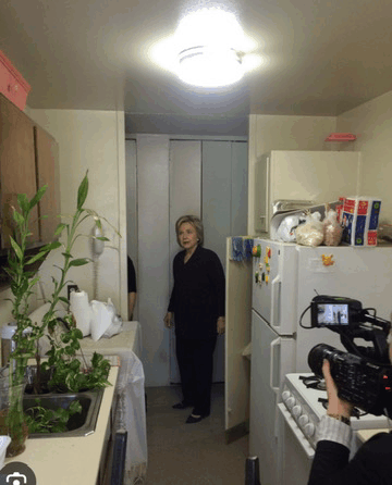 a woman is standing in a kitchen next to a refrigerator that has a sticker on it that says ' ice cream '