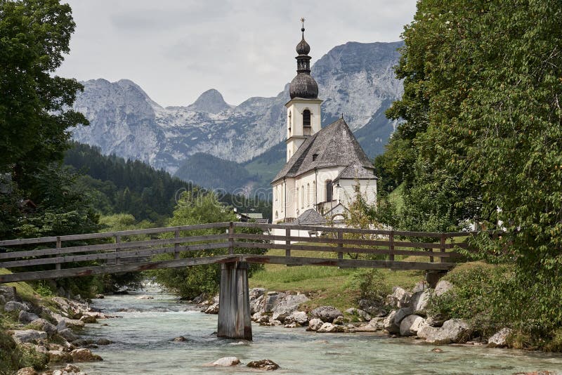picturesque-view-st-sebastian-church-next-to-mountain-creek-bridge-alps-mountains-background-summer-193961281.jpg