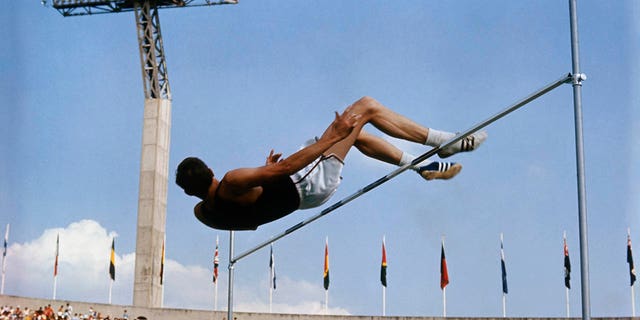 American high jumper Dick Fosbury clears the bar on his third attempt at the 1968 Summer Games in Mexico City. Fosbury won the gold medal with this jump, clearing 7 feet, 4 1/4 inches, which also set Olympic and American records.