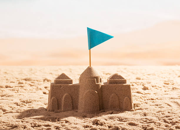 sand-castle-with-flag-on-the-sea-shore-picture-id621824110
